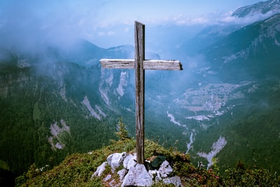 棕色的木十字架在悬崖的照片
